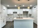 Modern kitchen with white cabinetry, island, and stainless steel appliances at 1212 Baltic Dr Way, Poinciana, FL 34759