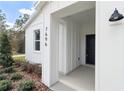 Inviting front entrance with a black door and white siding at 12281 Sw 75Th St, Dunnellon, FL 34432