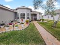 Landscaped front yard with walkway leading to the home entrance at 2446 Leaning Pine Ln, Oviedo, FL 32765