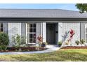Charming home featuring a gray brick exterior, a welcoming front door, and professional landscaping at 2823 Cady Way, Winter Park, FL 32792