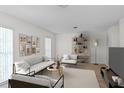 Bright living room featuring modern decor, a comfortable sofa and chairs, and stylish shelving at 2823 Cady Way, Winter Park, FL 32792