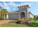 Curb appeal with gray exterior, brick driveway, and palm trees at 308 Vestrella Dr, Kissimmee, FL 34759