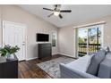 Living room with gray couch, dark wood floors, and access to a balcony at 3756 Idlebrook Cir # 206, Casselberry, FL 32707