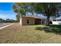 Tan house exterior with a large tree in front at 405 Kehoe Blvd, Orlando, FL 32825