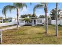 Cute bungalow with a spacious yard, palm trees, and a gray door at 4304 Mizell St, Orlando, FL 32812