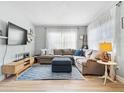 Light-filled living room with sectional sofa, large TV, and wood flooring at 4304 Mizell St, Orlando, FL 32812