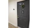 Modern dark gray condo entry door with wreath at 5550 E Michigan St # 2223, Orlando, FL 32822