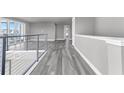 Modern hallway with gray walls, wood-look floors, and a metal railing at 7770 Sandy Ridge Dr # 240, Kissimmee, FL 34747