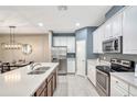 Modern kitchen with white cabinets, stainless steel appliances, and quartz countertops at 8749 Via Tavoleria Way, Windermere, FL 34786