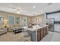 Open concept kitchen with island, stainless steel appliances, and a breakfast bar at 8749 Via Tavoleria Way, Windermere, FL 34786