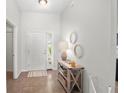 Bright entryway with wood console table, mirrors and tile floor at 110 Oak St, Clermont, FL 34711