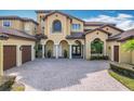 Front view of house with two-car garage and paver driveway at 12812 Jacob Grace Ct, Windermere, FL 34786