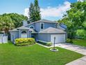 Charming home features a manicured lawn, two-car garage, and lush landscaping at 13111 Point O Wood Ct, Orlando, FL 32828