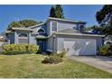 Two-story house with gray siding, white garage door, and manicured lawn at 13111 Point O Wood Ct, Orlando, FL 32828