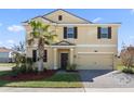 Two-story house featuring a tan exterior, brown accents, and a palm tree at 1504 Oak Marsh Loop, Davenport, FL 33837