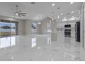 Bright, open-concept living space with large windows, marble floors, and a modern kitchen at 1700 Underwood Ave, St Cloud, FL 34771