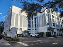 Exterior view of The Grande building, showing parking and landscaping at 202 E South St # 1050, Orlando, FL 32801