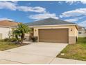 Tan house with gray roof, palm tree, and a two-car garage at 213 Lake Lucerne Way, Winter Haven, FL 33881