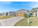 A beige house with a tan garage door and a neatly landscaped front yard at 2300 Grasmere View S Pkwy, Kissimmee, FL 34746