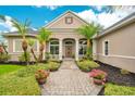 Inviting front entrance with a brick walkway and lush landscaping at 2682 Wyndsor Oaks Pl, Winter Haven, FL 33884