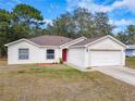 Exterior view of a one-story house with a red door and attached garage at 3054 Shallowford St, Deltona, FL 32738