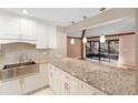 Modern kitchen with granite countertops, stainless steel appliances, and white cabinets at 360 Gleneagles Dr, New Smyrna Beach, FL 32168