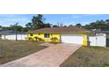 The house showcases a bright yellow facade, a neatly kept yard, and a brick-paved driveway, with a garage at 40 Lantana Dr, Debary, FL 32713