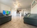 Open living area with tile floors, couches, and a view of the kitchen at 429 Fountainhead Cir # 122, Kissimmee, FL 34741