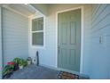 Inviting front entrance with light green door and small patio at 4708 Tribute Trl, Kissimmee, FL 34746