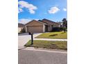 Tan house with a two-car garage and a landscaped lawn at 7132 Holly Creek Rd, Mount Dora, FL 32757