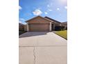 Two-car garage and a light brown house at 7132 Holly Creek Rd, Mount Dora, FL 32757