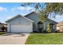 Newly painted light blue house with a white garage and lush green lawn at 1004 Hornbeam St, Oviedo, FL 32765