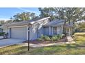 Gray single story home with a two-car garage, landscaping, and walkway at 1890 Silver Fern Dr, Port Orange, FL 32128