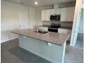 Bright kitchen featuring a large island, granite countertops, and stainless steel appliances at 2214 Lake Preserve Cir, New Smyrna Beach, FL 32168