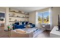 Cozy living room featuring a blue sofa, large window, and built-in shelving at 2968 Moulin Rd, Davenport, FL 33837