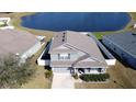 An aerial view of a house near a lake with a fenced backyard at 3105 Dasha Palm Dr, Kissimmee, FL 34744