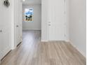 Bright entryway with light wood-look flooring, white doors, and a view into the living area at 332 Bow Ln, Haines City, FL 33844