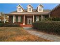 Inviting brick home featuring a covered porch, green shutters, and landscaped front yard at 34122 Park Ln, Leesburg, FL 34788