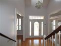 Bright foyer with hardwood floors, chandelier, and a decorative glass front door at 34122 Park Ln, Leesburg, FL 34788