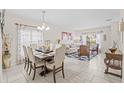 Bright dining room with a wooden table, beige chairs, and access to the living room at 34405 Alameda Dr, Sorrento, FL 32776