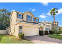 Two-story house with a yellow facade, gray roof, and a neatly landscaped lawn at 34405 Alameda Dr, Sorrento, FL 32776