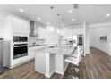 Well-lit kitchen featuring a large island with seating and modern stainless steel appliances at 4485 Lions Gate Ave, Clermont, FL 34711