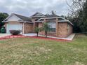 Brick house with a two-car garage and landscaped front yard at 113 W 1St St, Debary, FL 32713