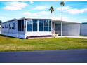 Mobile home with a large covered patio and grassy yard at 1401 W Highway 50 # 138, Clermont, FL 34711