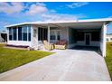 Mobile home with carport, covered patio, and landscaped lawn at 1401 W Highway 50 # 138, Clermont, FL 34711