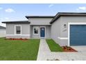 New construction home with gray exterior, blue garage door, and landscaped lawn at 15568 Sw 46Th Cir, Ocala, FL 34473