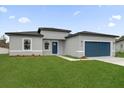 New construction home with gray exterior, blue garage door, and landscaped lawn at 15568 Sw 46Th Cir, Ocala, FL 34473