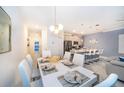 Open-concept dining area connected to kitchen, featuring a stylish table setting and modern pendant lighting at 2974 Protagonist St, Kissimmee, FL 34746