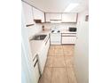 Well lit kitchen featuring tile floors, white appliances and white cabinets at 4111 S Semoran Blvd # 11, Orlando, FL 32822