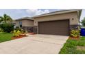 House exterior showcasing a brown garage door and stone accents at 4617 Harvest Row Ln, St Cloud, FL 34772